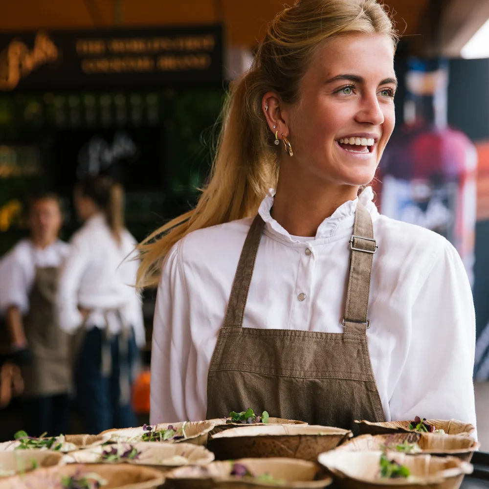 Bediening die een dienblad vasthoudt en lacht