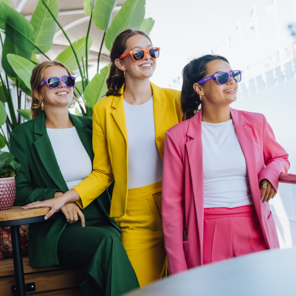 3 vrouwen in gekleurde pakken.